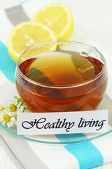 Healthy living card with cup of chamomile tea and lemon