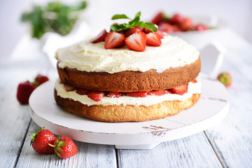 Delicious biscuit cake with strawberries on table close-up
