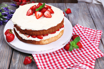 Delicious biscuit cake with strawberries on table close-up