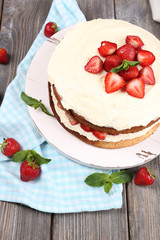 Delicious biscuit cake with strawberries on table close-up