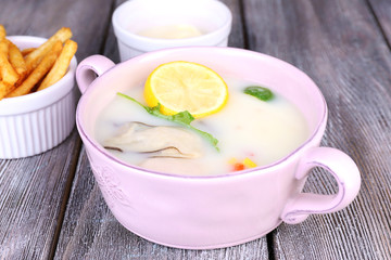 Tasty soup with oysters on wooden table