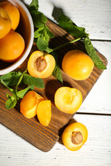 Ripe apricots with green mint leaves