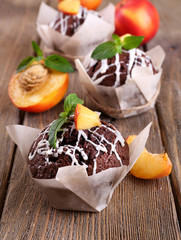 Tasty cupcakes with peach on table close-up
