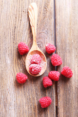 Ripe sweet raspberries in spoon on table close-up