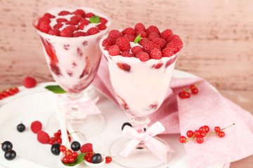 Tasty raspberry dessert with berries on pink wooden background