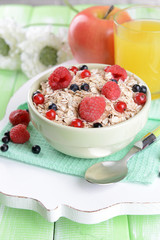 Tasty oatmeal with berries on table close-up
