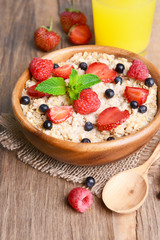 Tasty oatmeal with berries on table close-up