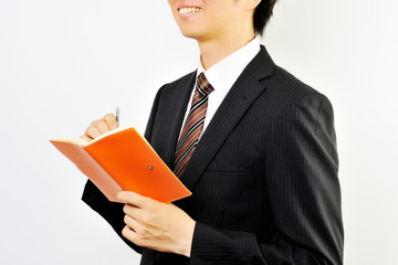 メモ帳を持っている黒いスーツのビジネスマン