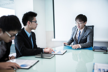 Young business people sitting in board room during meeting and d