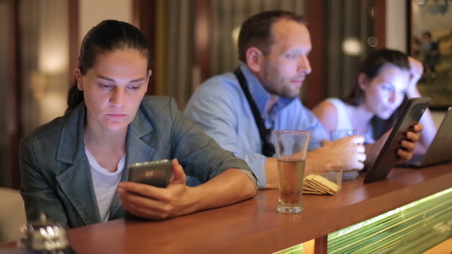Businesspeople working at night in pub on modern technology
