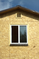 Wall from wooden panels with white plastic window  and roof