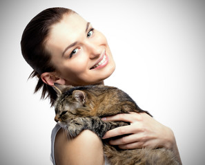 Cheerful woman with a beautiful smile holding cat