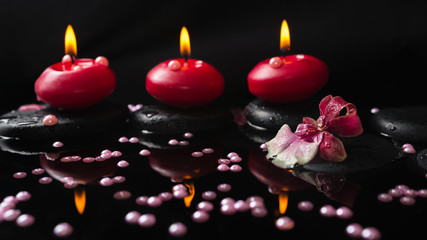 spa still life of red candles, zen stones with drops, orchid cam
