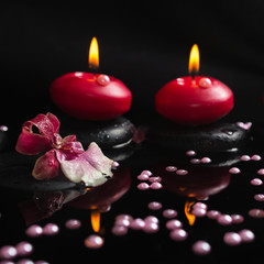 spa still life of red candles, zen stones with drops, orchid cam