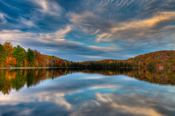 Fototapeta na wymiar Magical Reflections Trees lake blue skies cloud fall colors