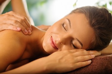 Beautiful young woman having massage in a spa salon - obrazy, fototapety, plakaty