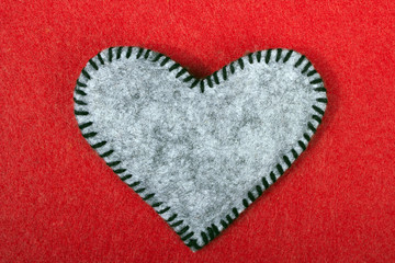 gray felt heart on a red background