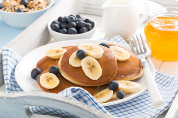 pancakes with banana, honey and blueberries for breakfast