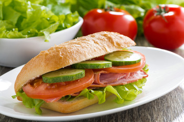 sandwich with ham and fresh vegetables on a plate