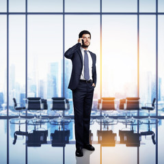 businessman standing in bright modern office with large windows