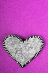 gray felt heart on a pink background