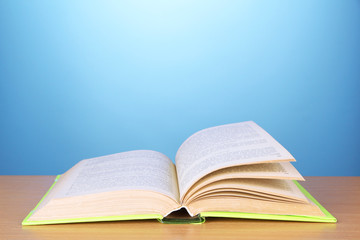Opened book on color background