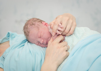 Young beautiful woman with a newborn baby after birth