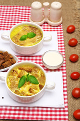 Tasty soup in saucepans on wooden table, close up