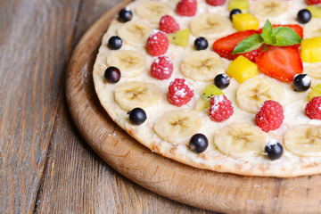 Sweet pizza with fruits on table close-up