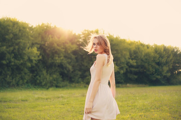 beauty woman in dress portrait over bright daylight background