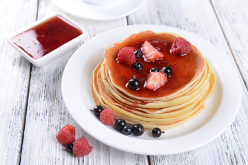 Sweet pancakes with berries on table close-up