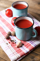 Homemade tomato juice in color mugs, spices and fresh tomatoes