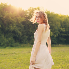 Fototapeta na wymiar beauty woman in dress portrait over bright daylight background