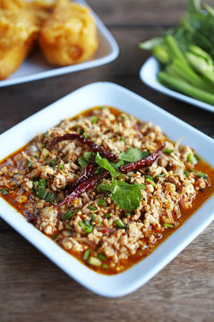 close up thai spicy pork salad in plastic dish
