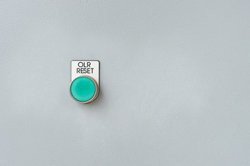 Green reset button on the wall