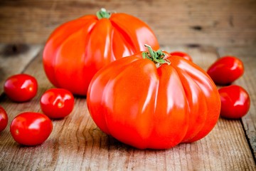 Fresh red heirloom tomatoes on a wooden background
