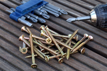 Akkuschrauber, Schrauben mit Bits auf Holzdiele