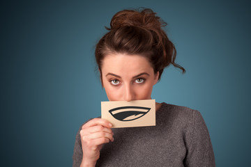 Pretty young girl holding white card with smile drawing