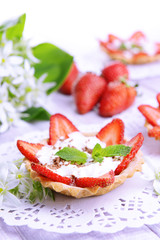 Tasty tartlets with strawberries on table close-up
