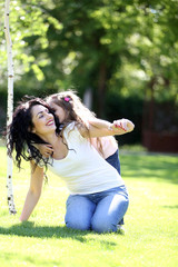 Obraz premium Happy mom and daughter. Walk in the green park