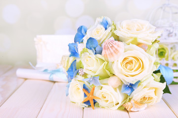 Beautiful wedding bouquet with sea decor on wooden table