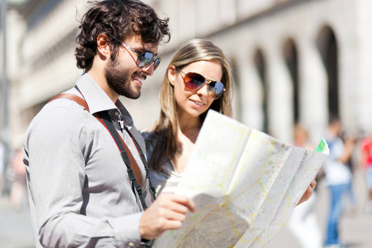 Couple of tourists reading a map in a city