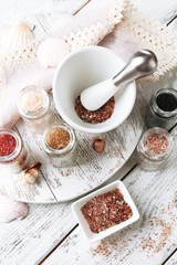 Different sea salt on wooden table, close up