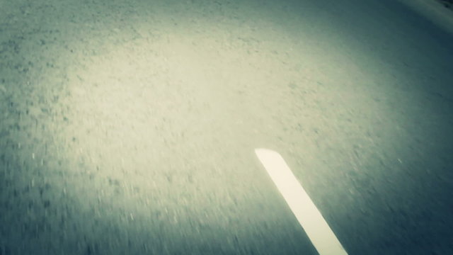 Driving on the road close-up with flashing road markings.
