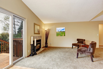 Empty living room in soft ivory with fireplace and walkout deck