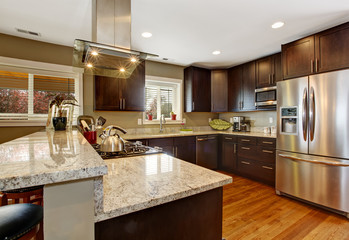 Dark brown kitchen room with steel appliances