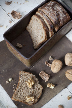 homemade wholemeal sliced bread on vintage box with walnuts