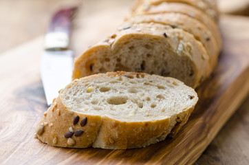 bread with seeds on a wooden board and knife