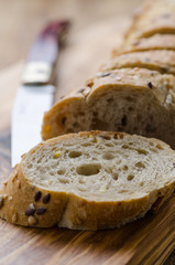 bread with seeds on a wooden board and knife