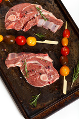 Raw lamb chops with tomato ready to cook. Selective focus.